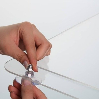 Hands fitting a metal standoff bolt to a clear acrylic panel